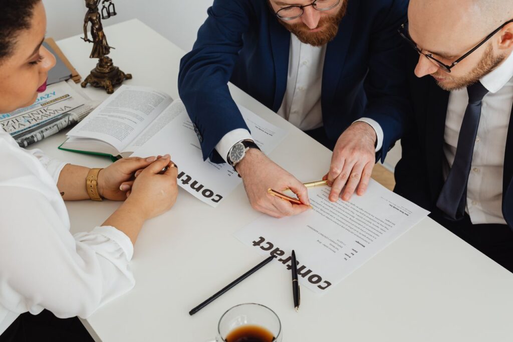 Business professionals engaged in contract review at a modern office desk.